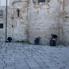 Alcuni volontari ripuliscono la facciata dell'abside di Ognissanti