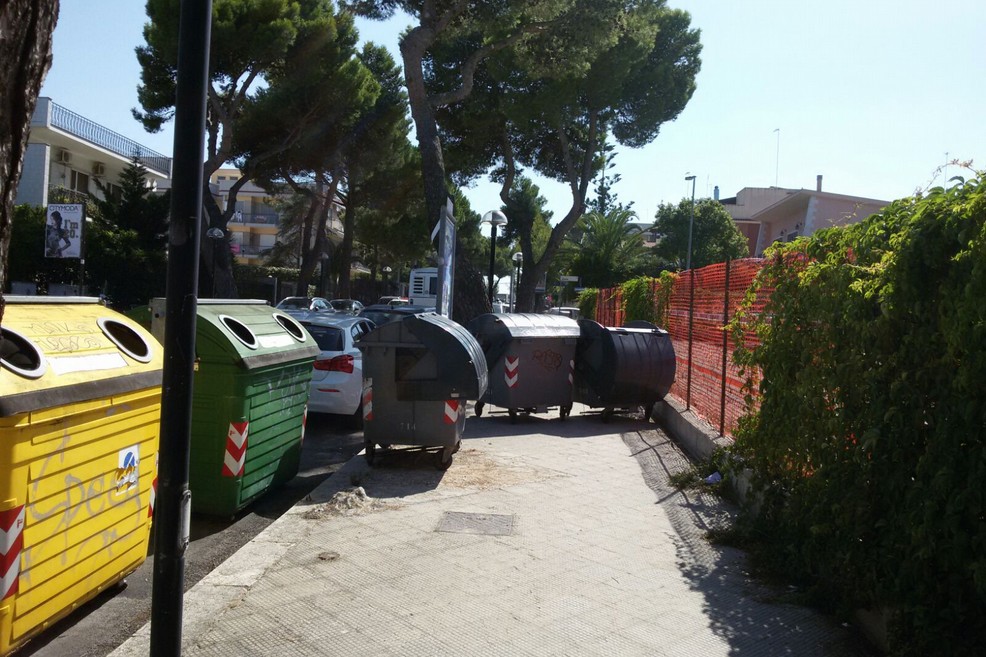 Viale di Colonna, automobilista sposta i bidoni sul marciapiede per parcheggiare