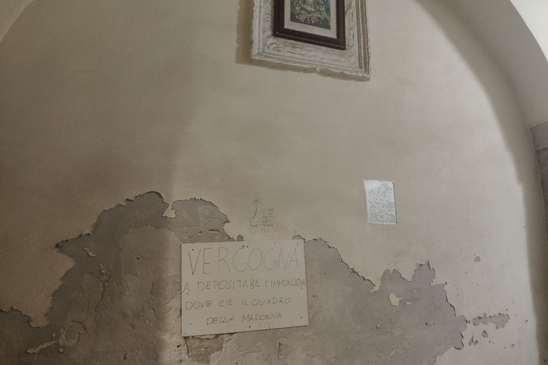 Cartelli contro la spazzatura sotto il quadro della Madonna di vico San Martino. <span>Foto Adriana Fabrizio</span>